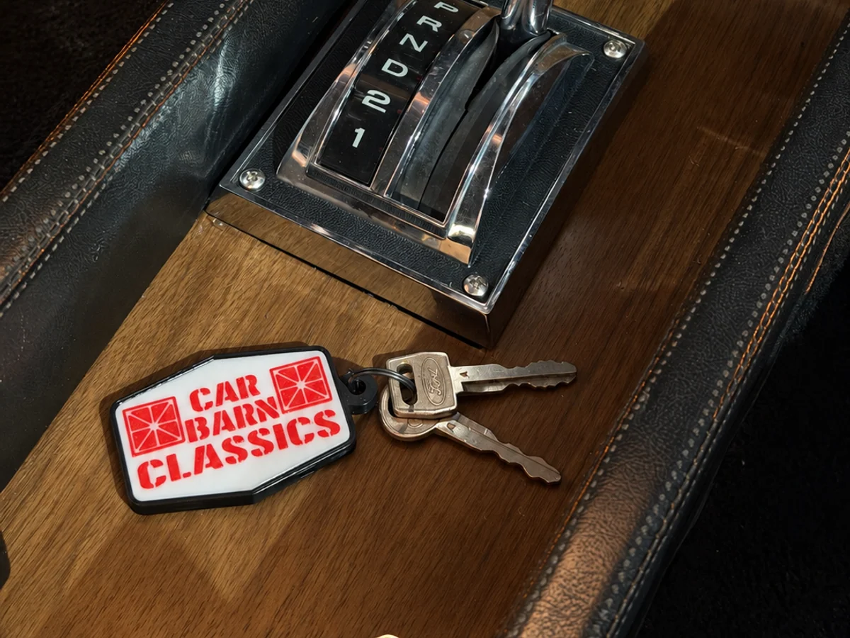 Custom logo keychain and keys beside the shifter in a classic car interior