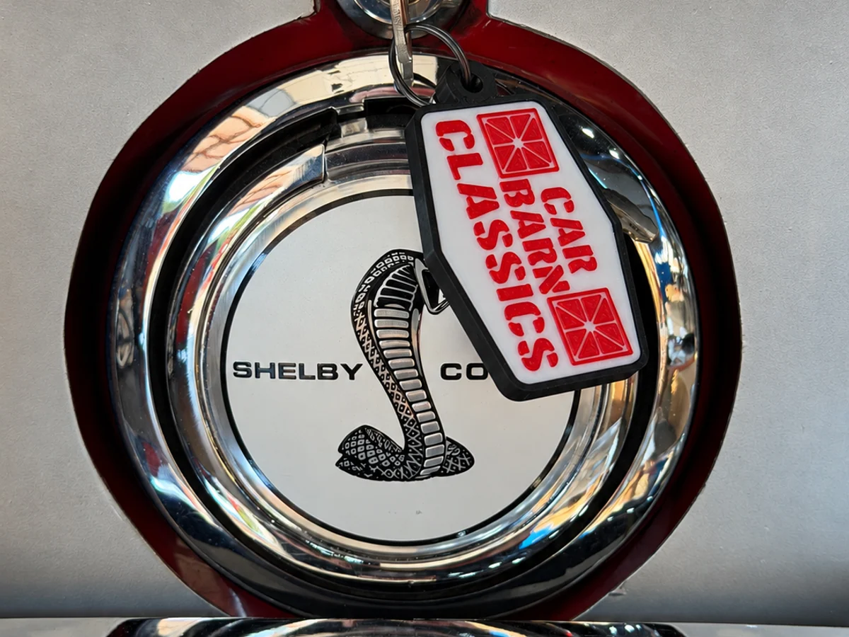 Custom logo keychain displayed on a classic Shelby fuel cap